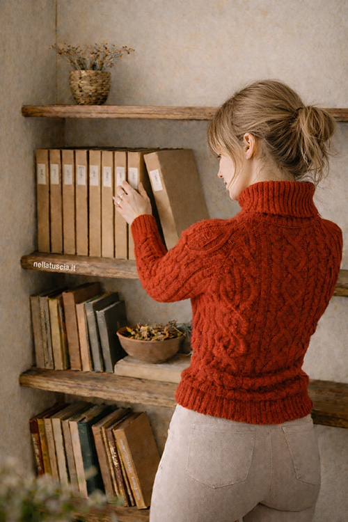 Elisa raggiunge lo scaffale e prende le fotografia per Gianni.