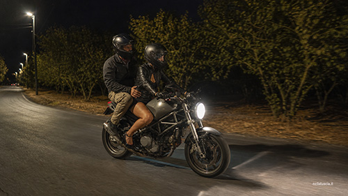 Arthur e Livia in moto sulla strada di notte e lei alla guida.